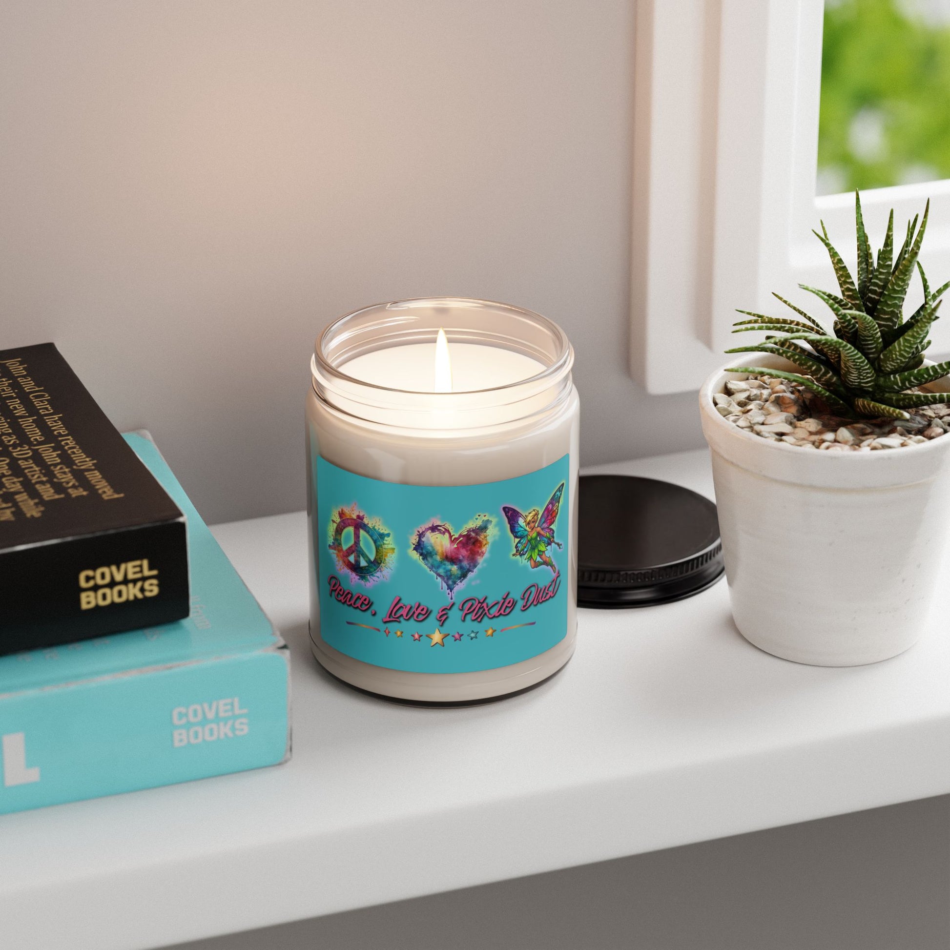 Candle with a blue label on a shelf next to books and a plant